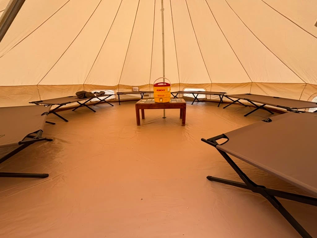 Inside a safari tent — cots around the center pole